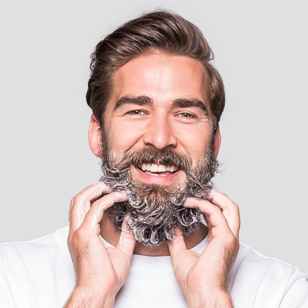 Man lathering beard with soap, smiling