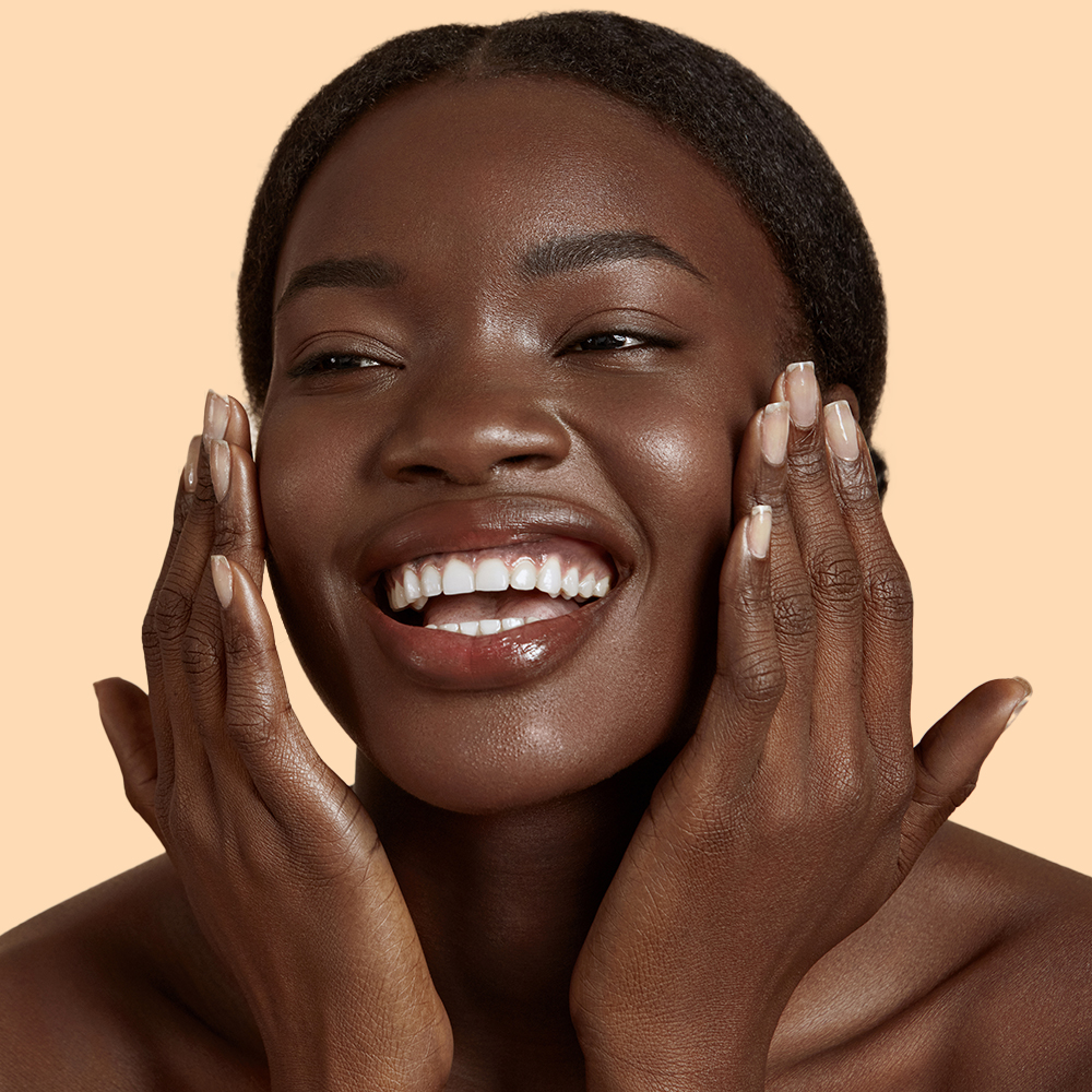 Smiling person with hands on cheeks