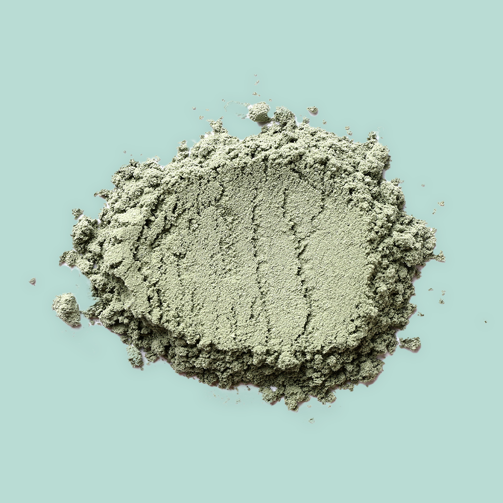 Pile of green powder on teal background.
