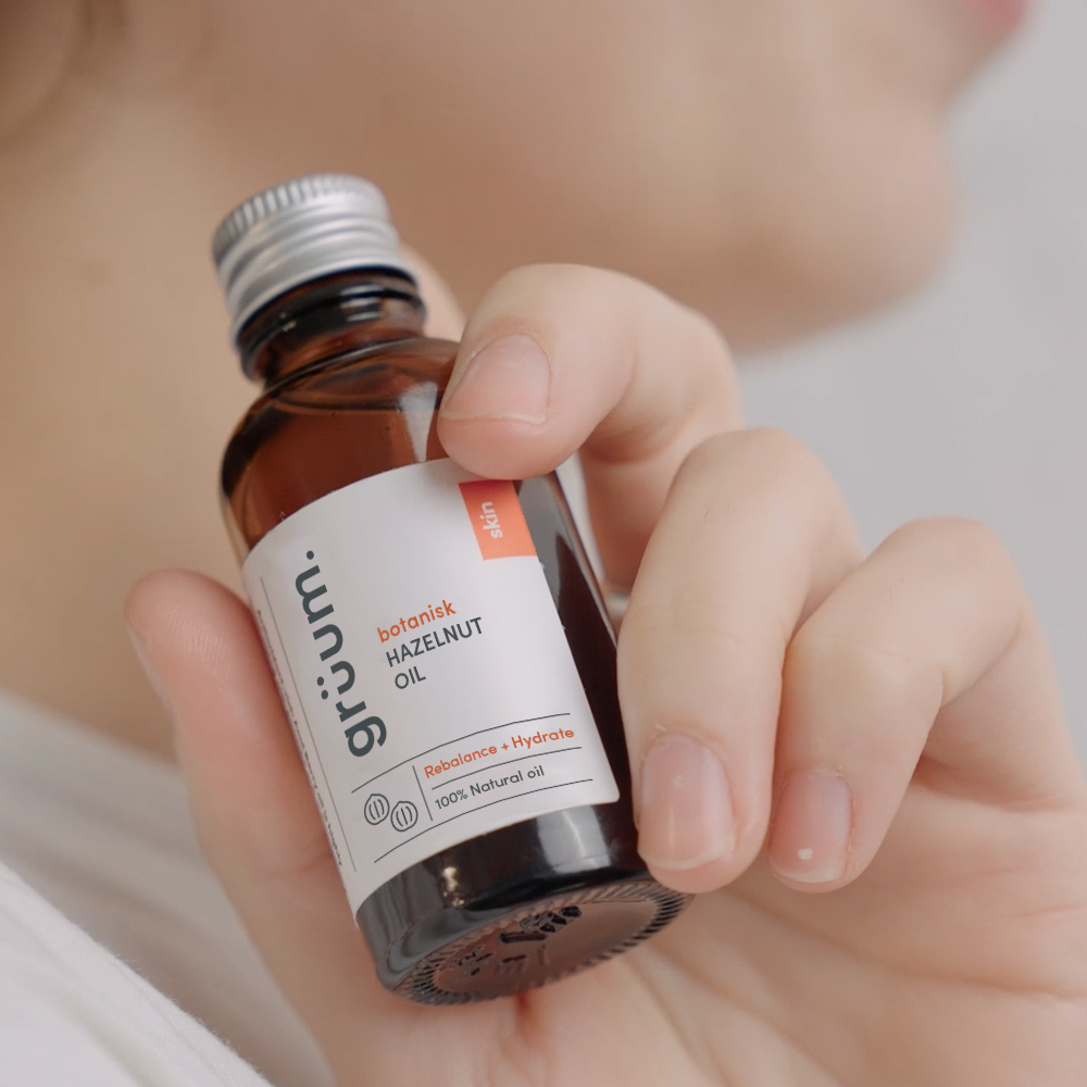 Hand holding hazelnut oil bottle