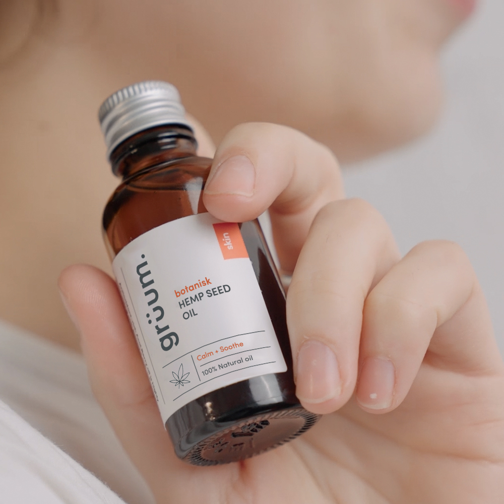 Hand holding hemp seed oil bottle.