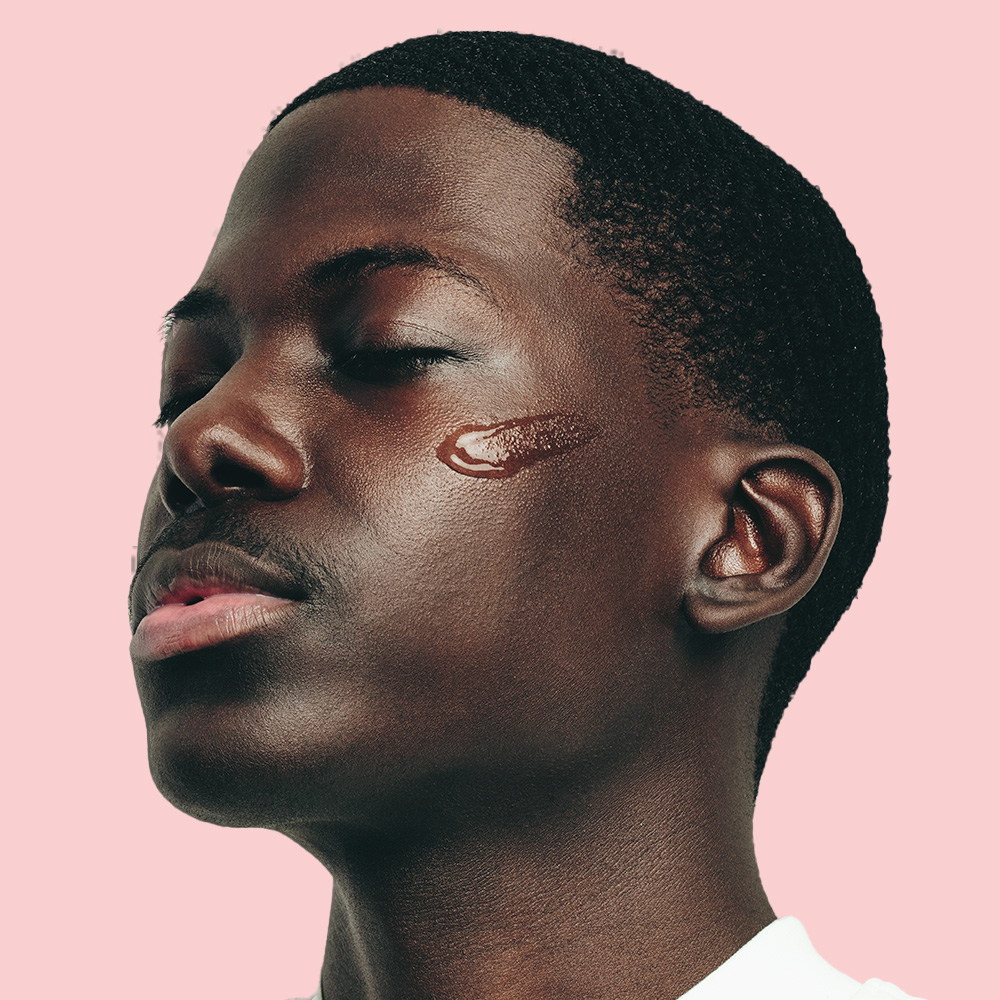 Person with facial cream, pink background