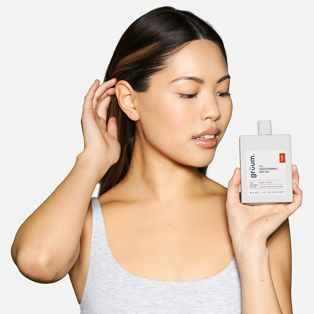 Woman holding skincare product near face