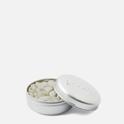 Open tin with small white tablets
