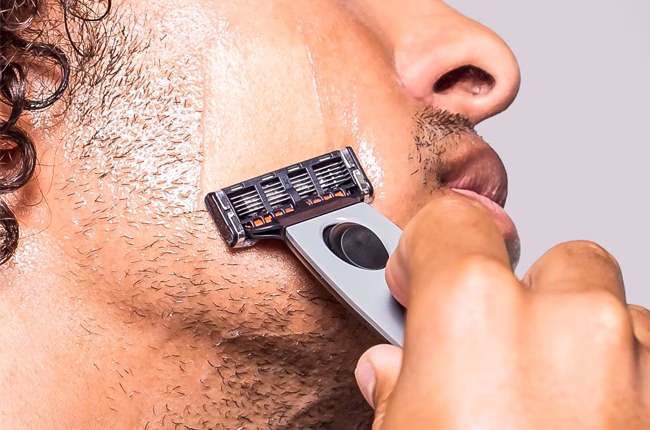 Close-up of person shaving face