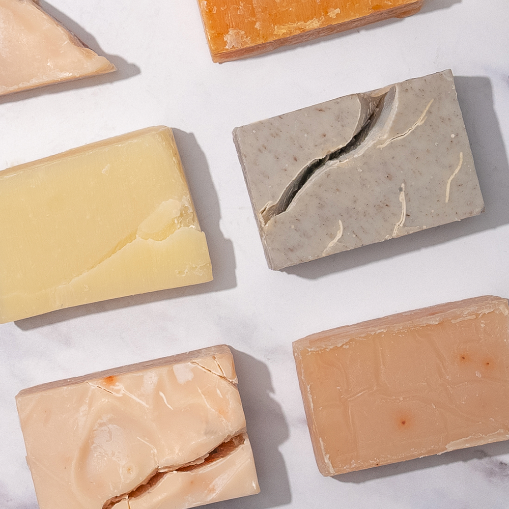 Assorted handmade soap bars on white background.