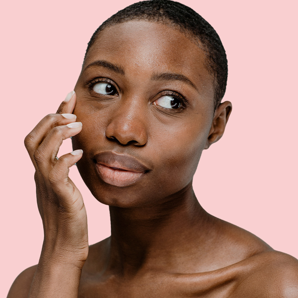 Person touching face, pink background