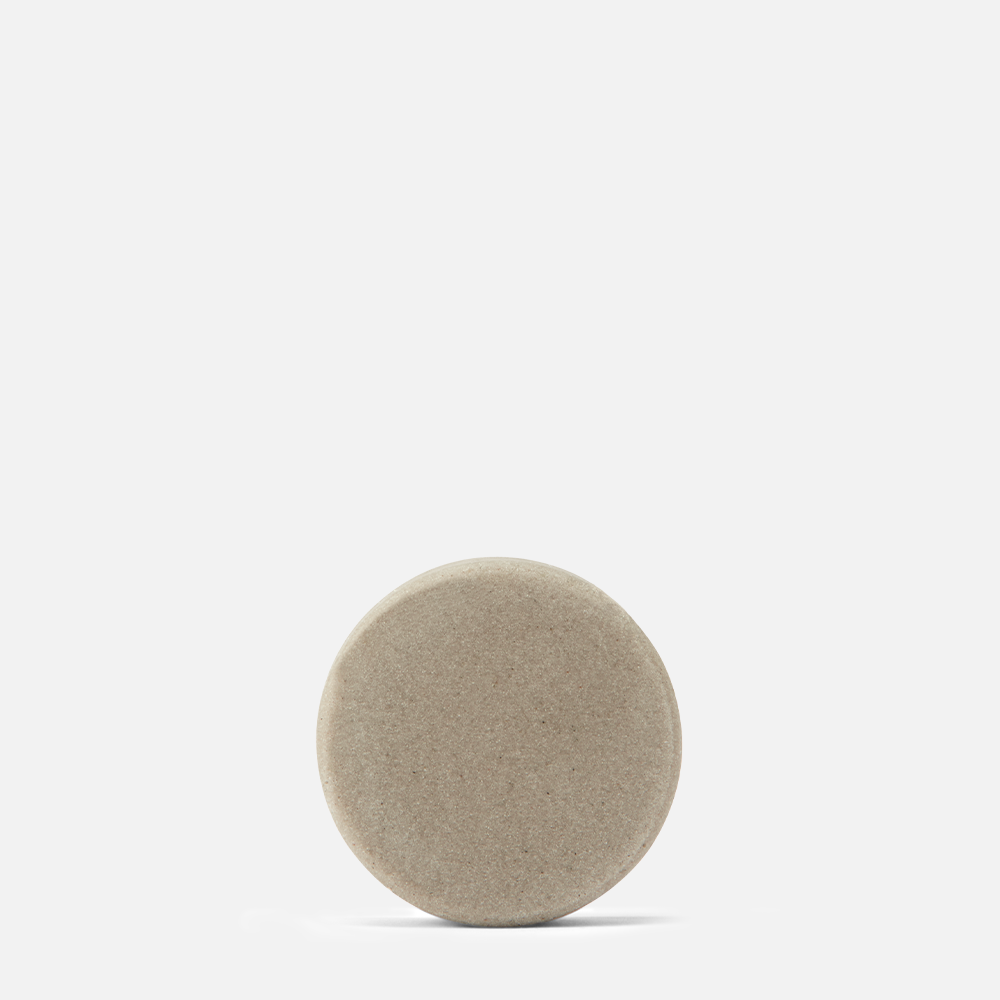 Round beige stone on white background.