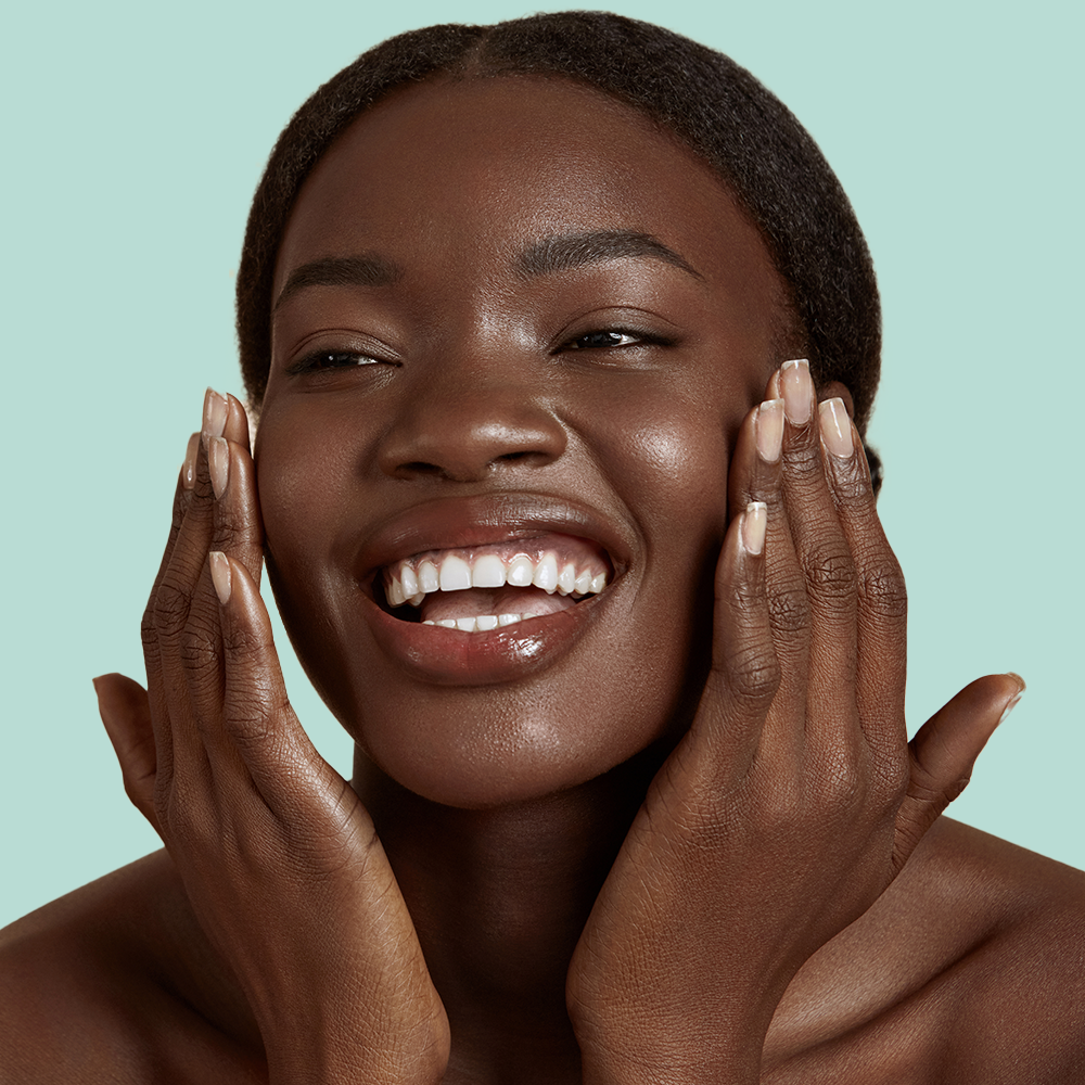 Smiling woman touching face