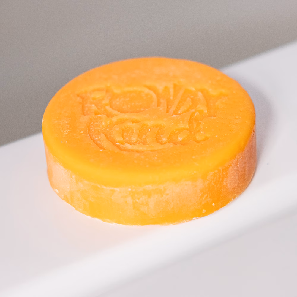 Orange round soap on white surface.