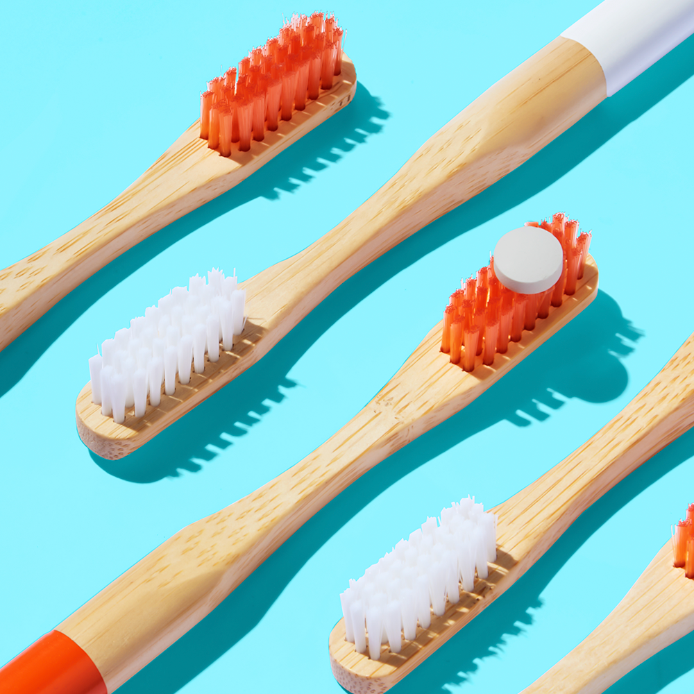 Wooden toothbrushes on blue background.