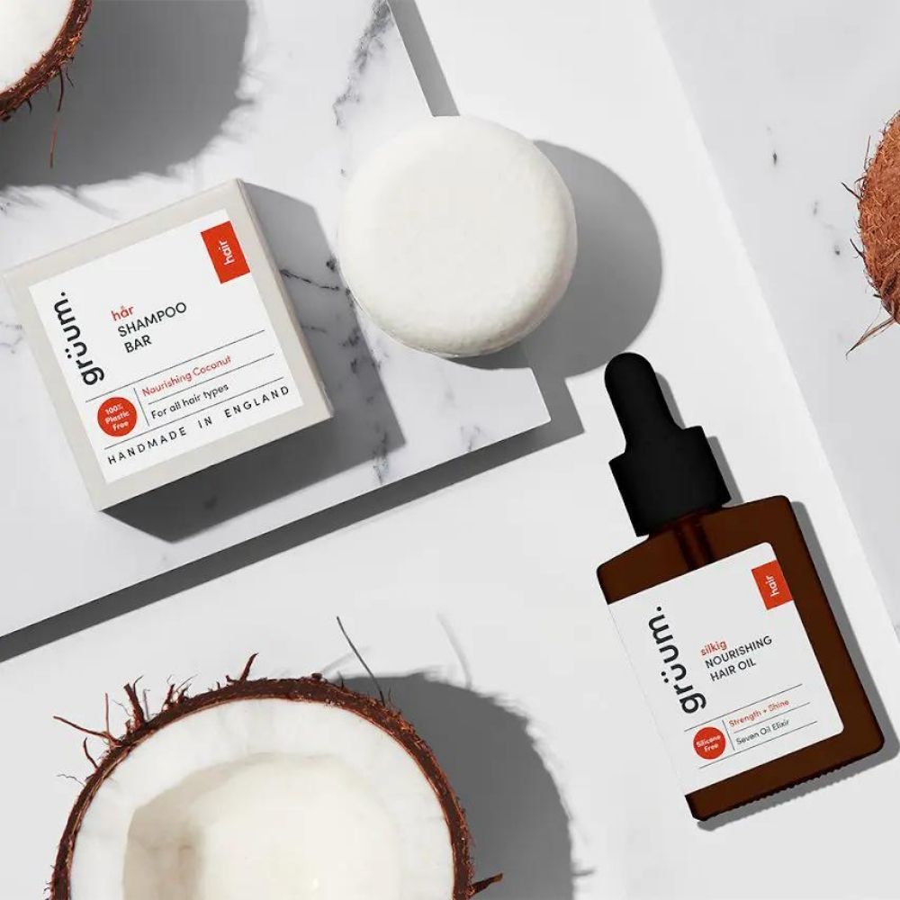 Shampoo bar, oil, and coconuts on marble