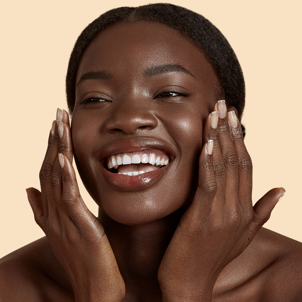 Smiling person touching face with joy.