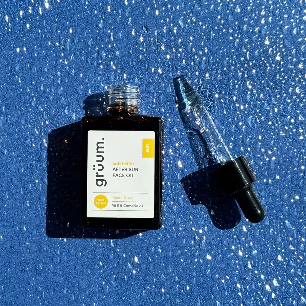 Face oil bottle on blue surface