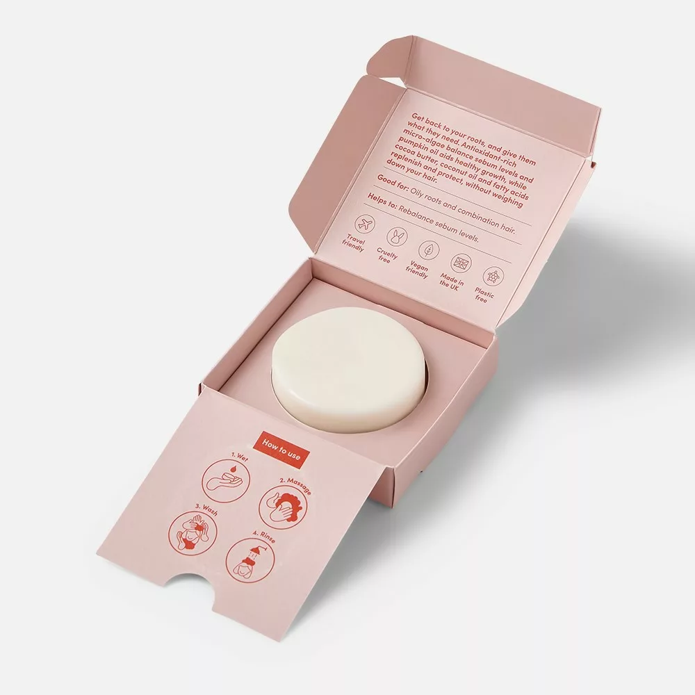 Open pink box with round product inside.