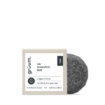 Black shampoo bar with packaging.