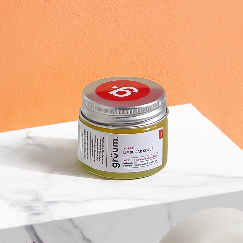 Lip sugar scrub jar on marble surface.