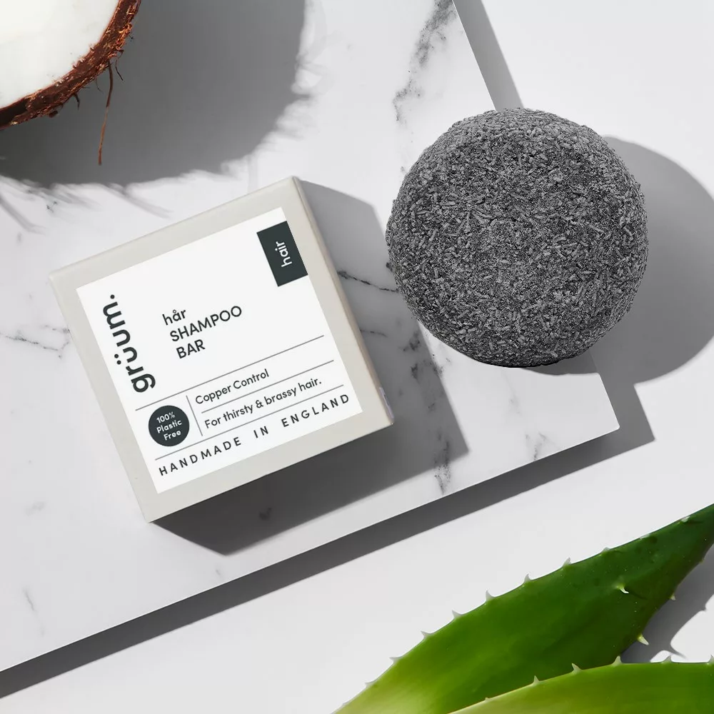 Shampoo bar with packaging on marble surface.