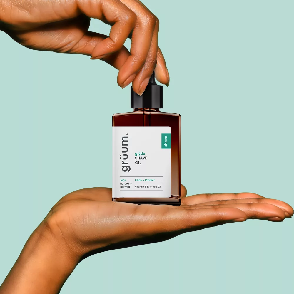 Hands holding a shave oil bottle.