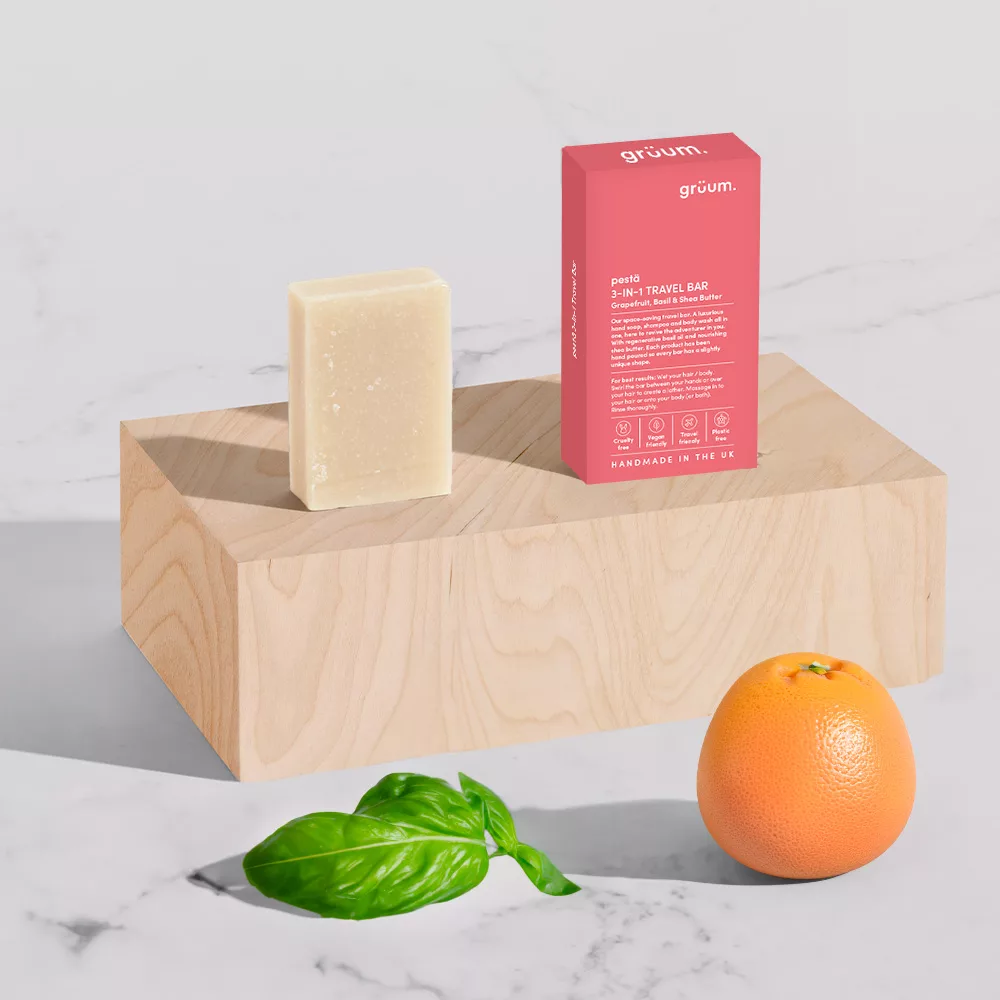 Soap, box, orange, basil on wooden platform.