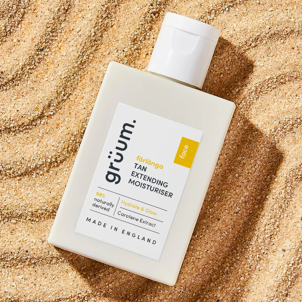 Tan moisturizer bottle on sand