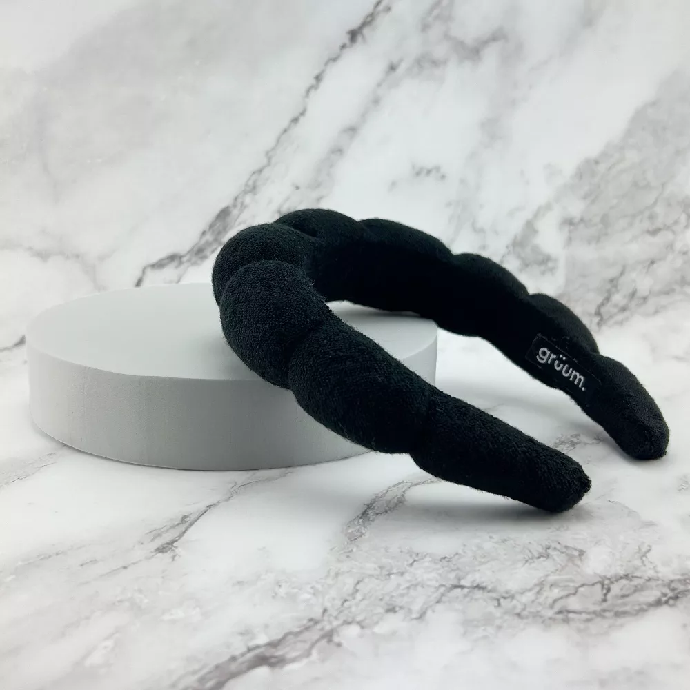 Black headband on marble surface.