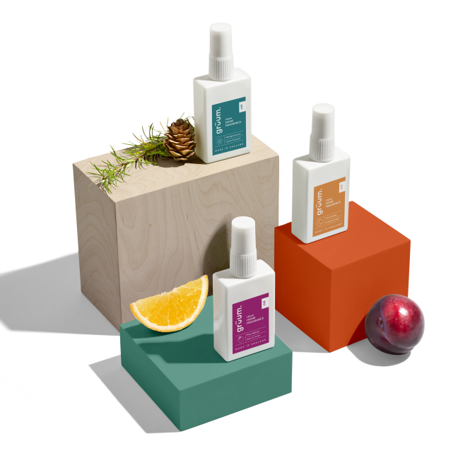 Three perfume bottles on colorful blocks.