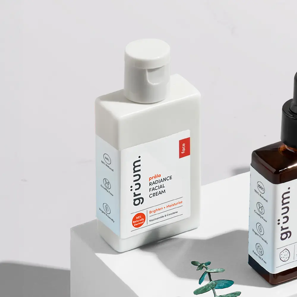 Facial cream and bottle on white surface.