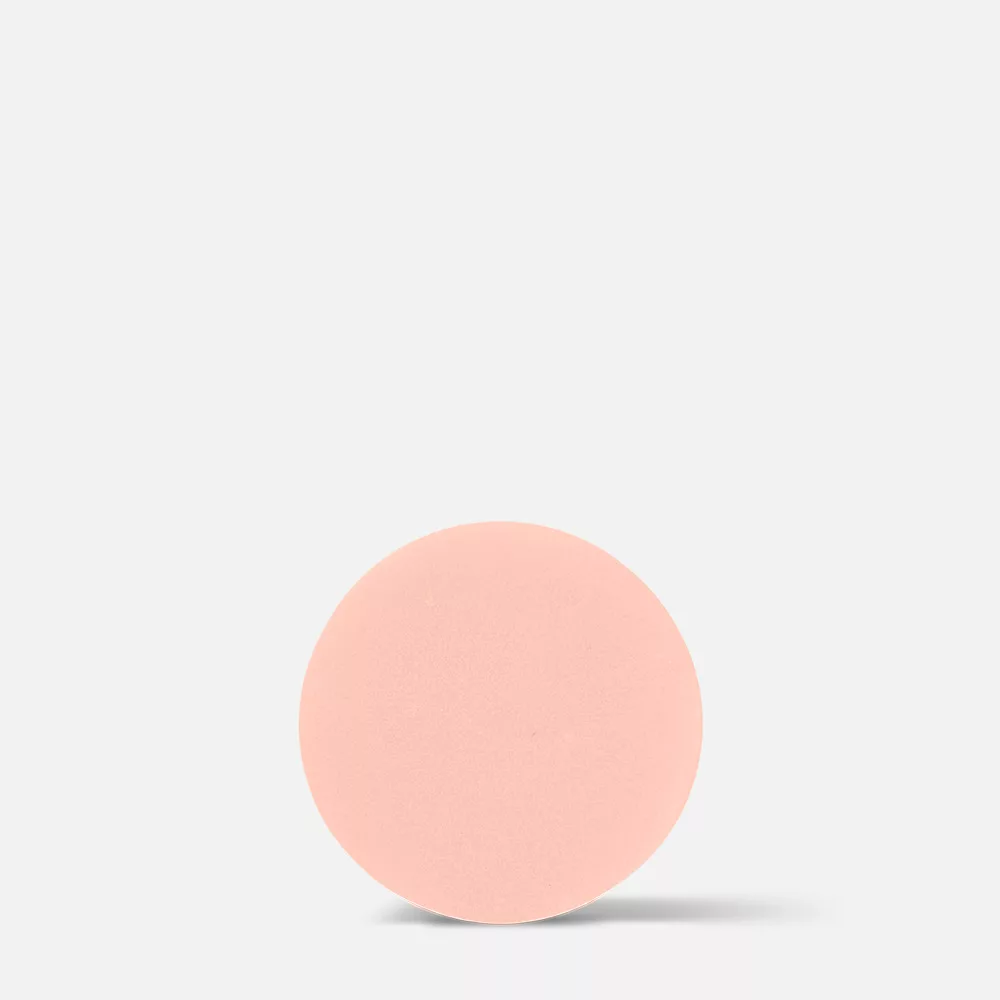 Pink round tablet on white background.