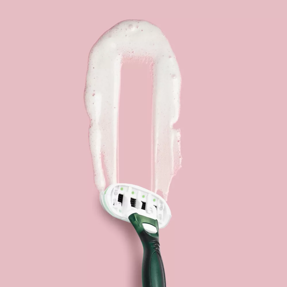 Razor on pink background with foam