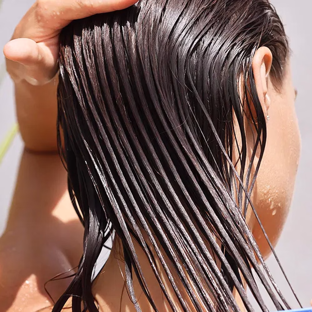 Person with wet hair being rinsed