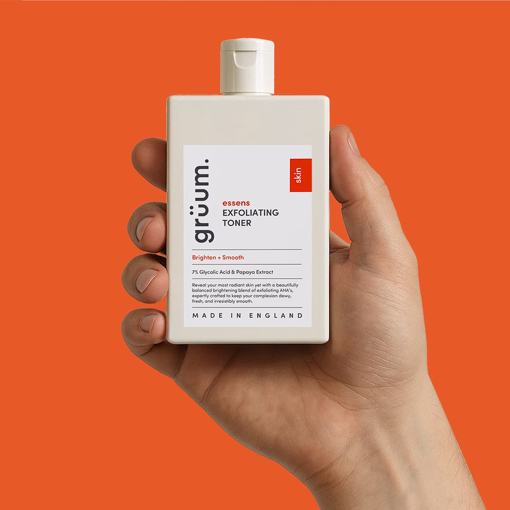 Hand holding exfoliating toner bottle.