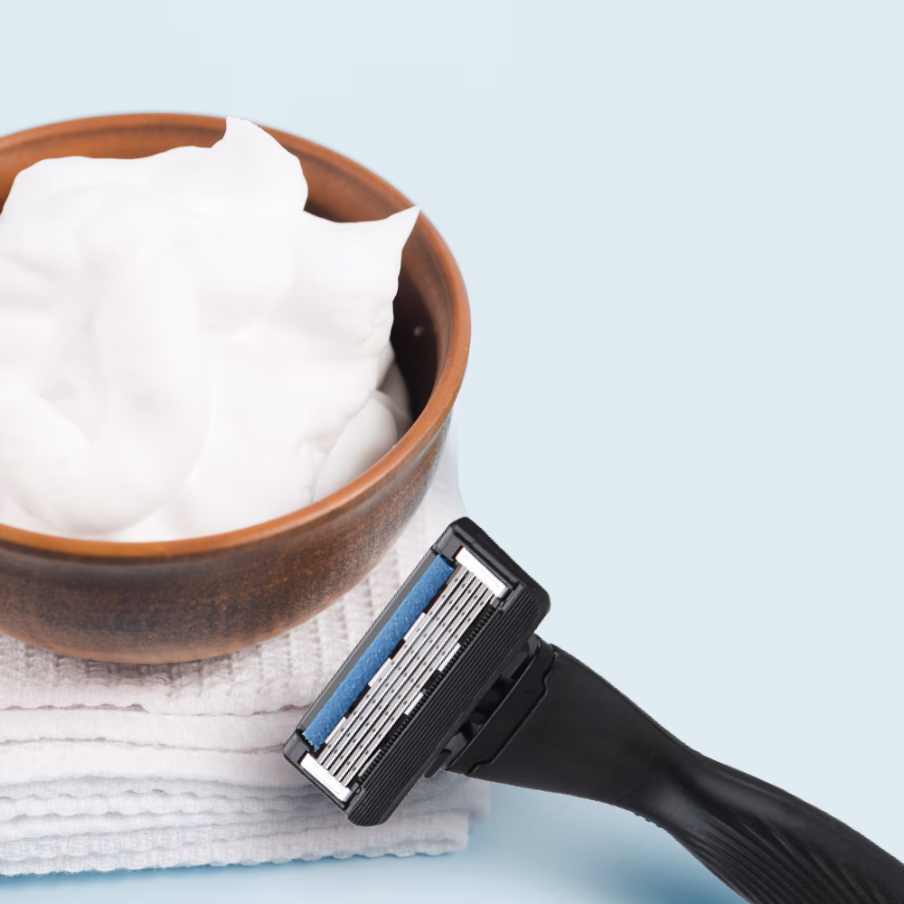 Shaving cream and razor on towels.